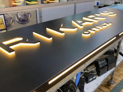 Insegna luminosa in alluminio 20/10 verniciatura a polvere in nero opaco con lettere massello retroilluminate a luce indiretta